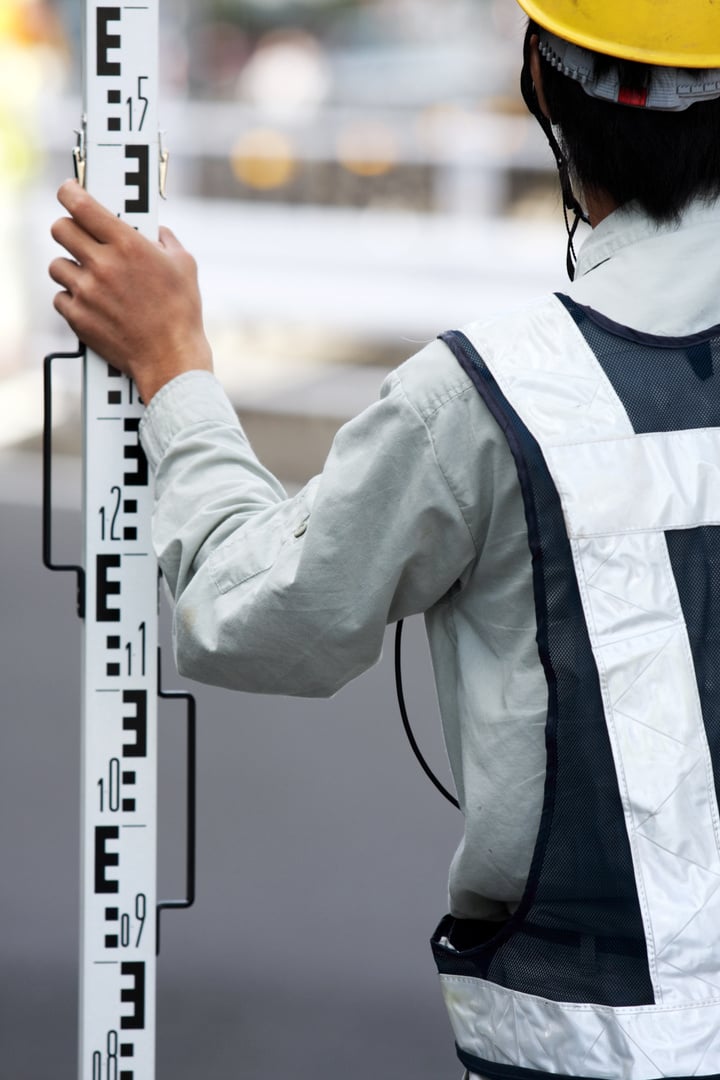 Surveyor holds a level rod